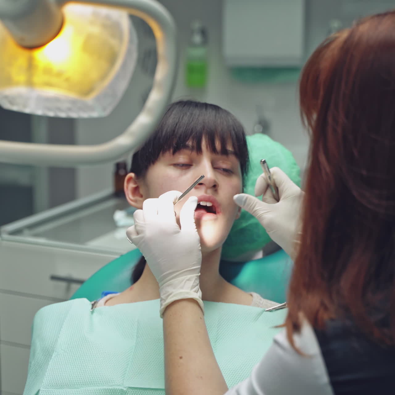 Dental clinic. Woman dentist working at her patients teeth