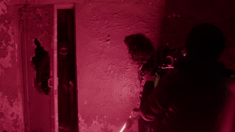 cameraman and production worker recording a scene of an man in black balaclava holding an ax in a ruined building