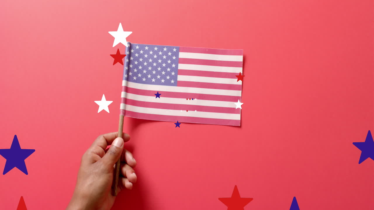 Animazione di stelle che cadono sopra una mano che tiene la bandiera degli Stati Uniti d'America su sfondo rosso