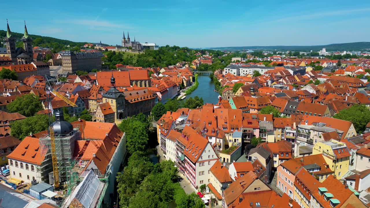 Video aereo 4K con drone di gru edili vicino alla Cattedrale di Bamberga e all'Abbazia di Michaelsberg lungo il fiume Regnitz, nella zona storica della città vecchia di Bamberga, Germania