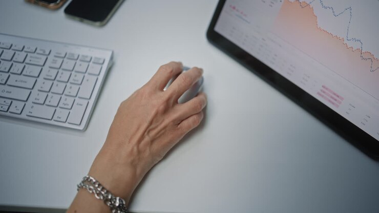 Top View on Female Stock Exchange Trader Using Computer Mouse, Analyzing Real-Time Stocks, Exchange Market Charts Using Digital Tablet. Investment Agent Working in Financial Agency Office. Close Up.