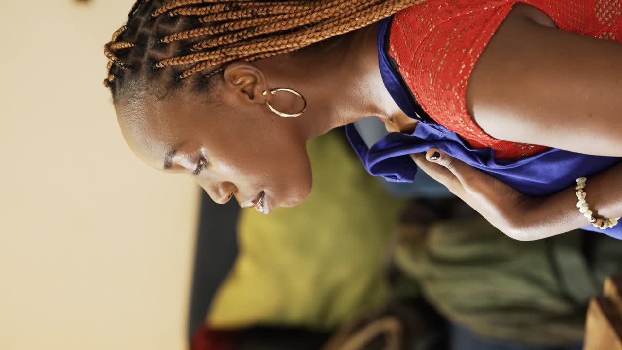 우간다 여성이 메이크업 세션에 참여하고 있습니다. 수직 촬영