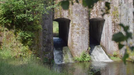 agua que fluye a través de arcos de piedra