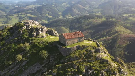 aerial drone view of the hermitage of santa eufemia on the top of a mountain in aulestia in the basque country