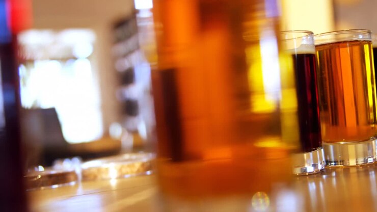 Tre bicchieri di whisky sul bancone del bar, 4K