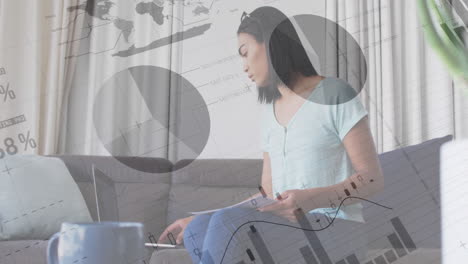 animación de procesamiento de datos financieros sobre una mujer de negocios biracial usando una computadora portátil