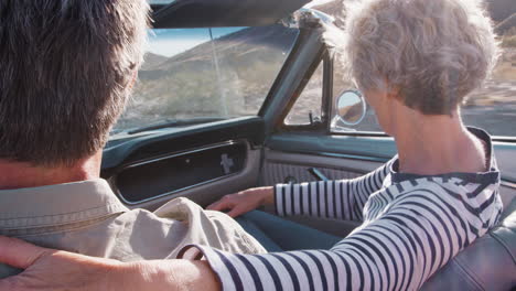 una pareja de ancianos en un coche abierto, una mujer en el asiento del pasajero, de cerca.