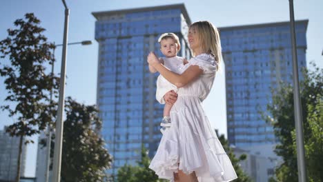 happy woman dancing with baby daughter outdoors