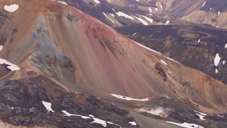 fixed global view of the multicolored brennisteinsalda mountain, featuring solfataras, sulfur fumaroles, and smoke at the bottom