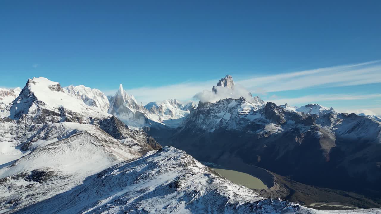 Drone panorama over Laguna Torre near El Chaltén. Majestic Fitz Roy and Cerro Torre peaks stand snow-covered beneath a cloudless sky in Patagonia’s rugged Andes