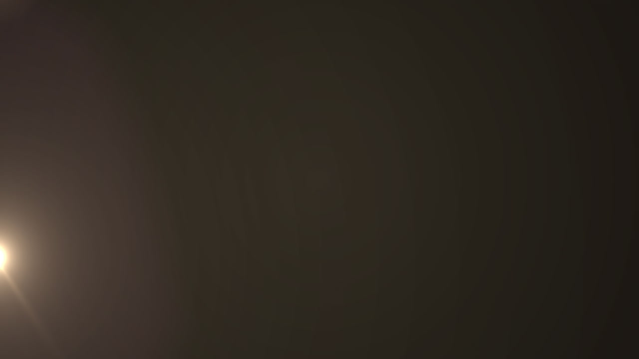 Glowing white spot of light flickering against brown background