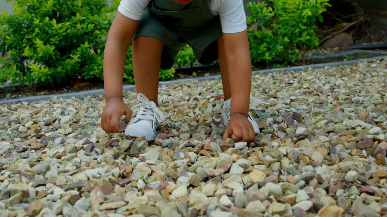 귀여운 작은 흑인 아기가 집 4k의 뒷마당에서 놀고 있는 전면 전망