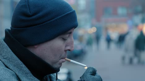 close-up shot of a man lighting a cigarette in the streets of rotterdam