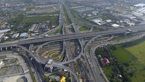 aerial view of highway road interchange with busy urban traffic speeding on road