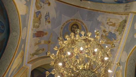 christian iconography on ceiling frescos over ornate golden chandelier