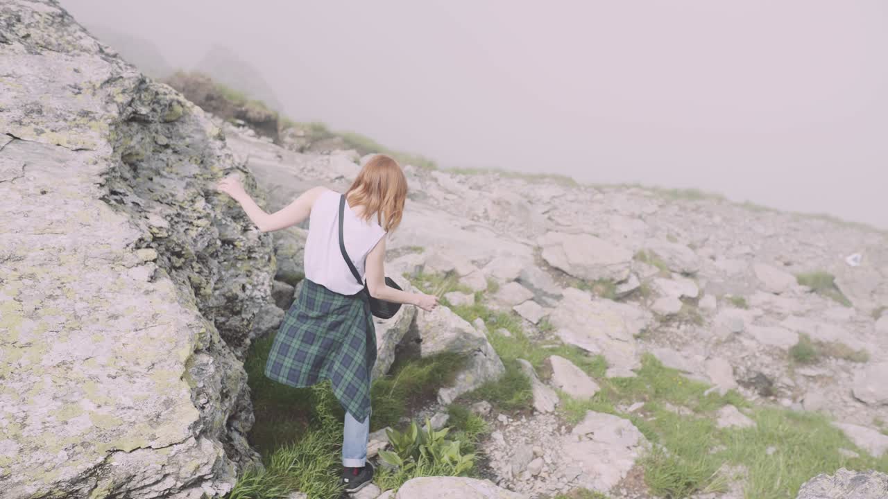 젊은 여성 하이커가 사진 카메라로 산을 등반합니다. 트랜스파가라산, 루마니아의 카르파티아 산맥