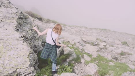 a young woman hiker climbs mountains with photo camera. transfagarasan, carpathian mountains in romania