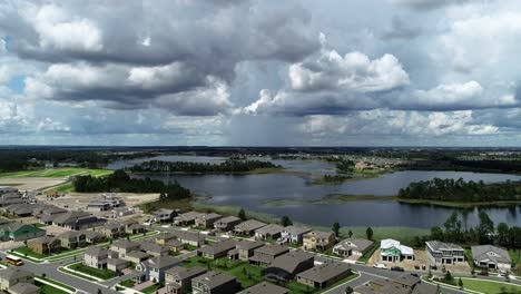 Aerial-view-of-an-upper-middle-class-lakefront-neighborhood-subdivision-with-single-family-homes-and-townhouses,-pool-and-clubhouse-on-a-cloudy-fall-day-in-Winter-Garden,-Florida,-USA