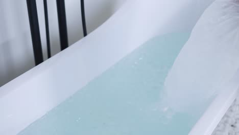 unrecognizable man filling bath with ice cubes, close up