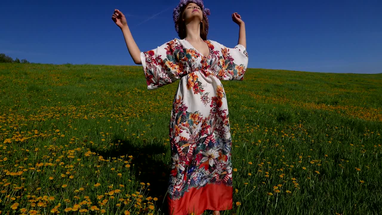 보호 드레스를 입은 히피 소녀가 들판을 가로질러 고 있습니다.