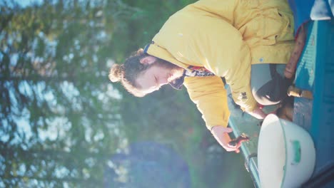 Vertical---Male-Camper-Preparing-Freshly-Caught-Fish-For-Cooking