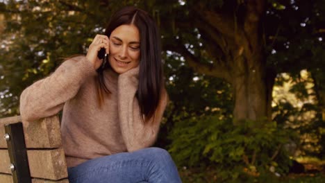 Pretty-brunette-using-phone-in-park