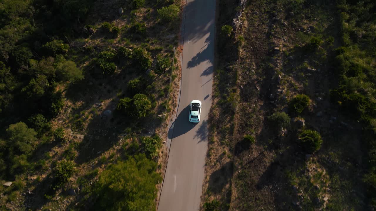 macchina moderna che guida lungo una strada a bella serra de tramuntana con colline verdi