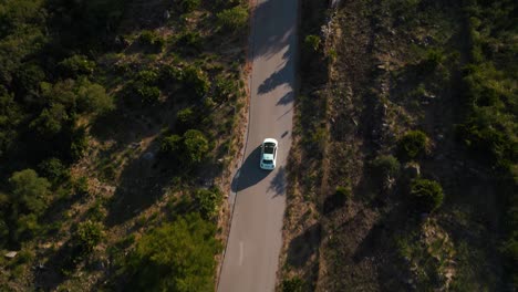 coche moderno conduciendo a lo largo de una calle en la hermosa serra de tramuntana con colinas verdes