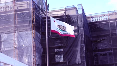 california flag waving in the wind in front of an art museum currently undergoing construction in san mateo