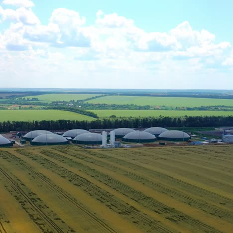 flight over biogas plant. biogas plant from sewage treatment in green fields