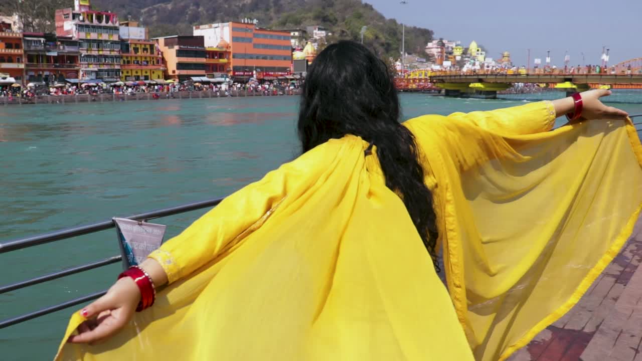 niña aislada disfrutando en el río sagrado ganges en la orilla del río desde un ángulo plano se toma un video en la orilla del río ganga haridwar uttrakhand india