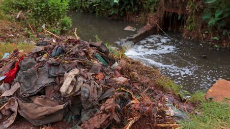 Río-Contaminado-Con-Bolsas-De-Plástico-Flotando---Arroyo-Contaminado-En-Kenia,-África-Oriental