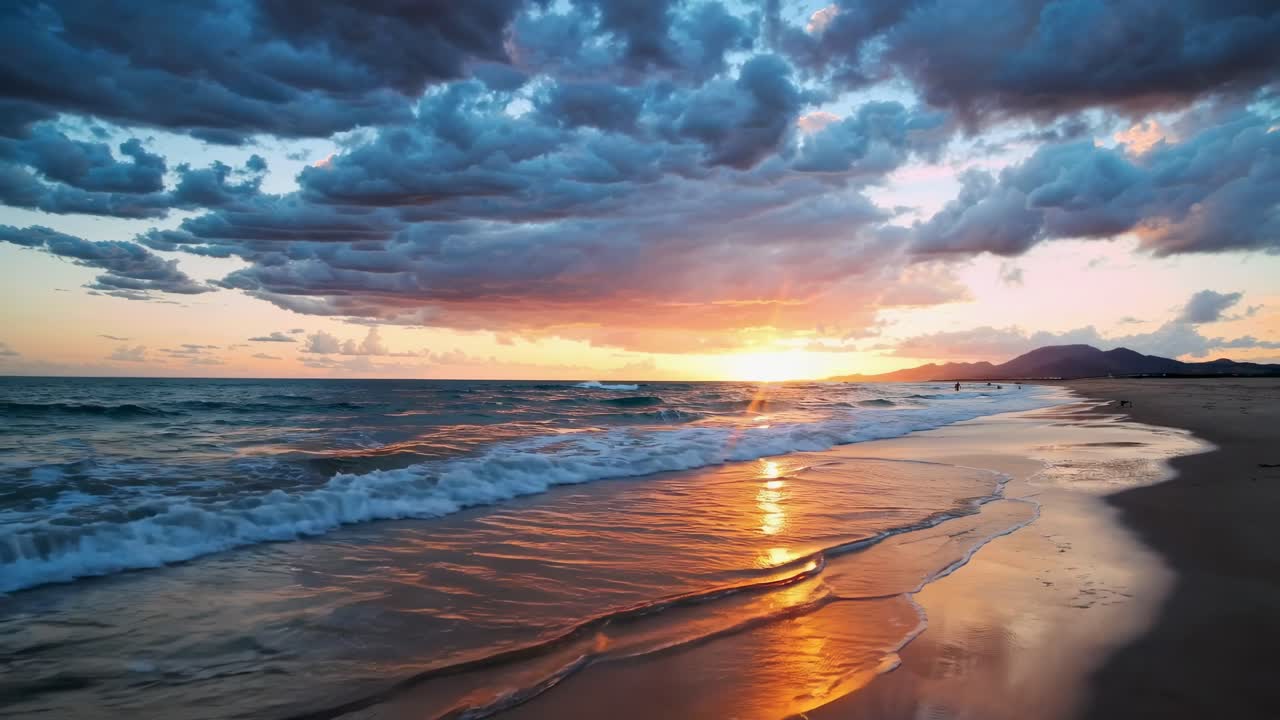 A stunning sunset video captures waves gently lapping a sandy beach