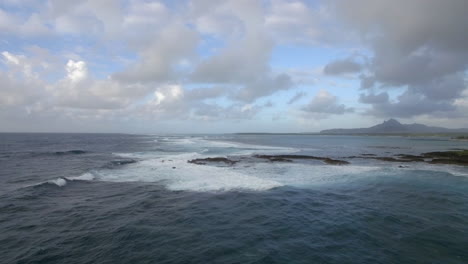 Luftaufnahme-Der-Wasserlinie-Der-Meere,-Die-Sich-Nicht-Mit-Dem-Blauen-Himmel-Und-Den-Wolken-Auf-Der-Insel-Mauritius-Vermischen