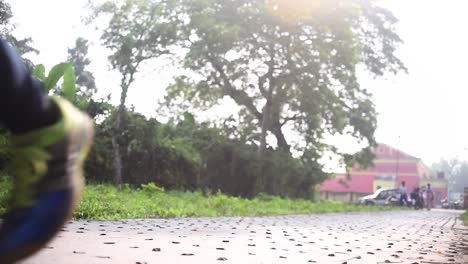 young girl jogging towards camera at morning sunrise or evening sunset on road, low angle shot