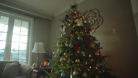 Dolly-Des-Weihnachtsbaums-Mit-Dekorationen-Und-Sonne,-Die-Durch-Das-Fenster-Strömt
