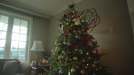 dolly of christmas tree with decorations and sun pouring through the window