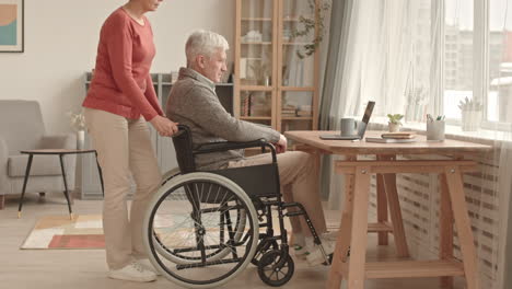 elderly man using laptop with caregiver support