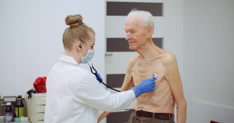 female doctor examine elderly man with stethoscope