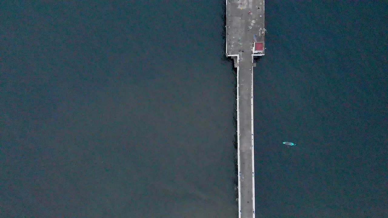 드론, 폰디체리, 인도와 함께 바위 해변 근처에 몬순 구름이 덮힌 일출에 선적항 부두의 4k 공중 하향식 풀업 샷