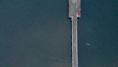 4k aerial top down pull up shot of a shipping port pier on a sunrise with monsoon clouds covered near rock beach shot with a drone, pondicherry, india