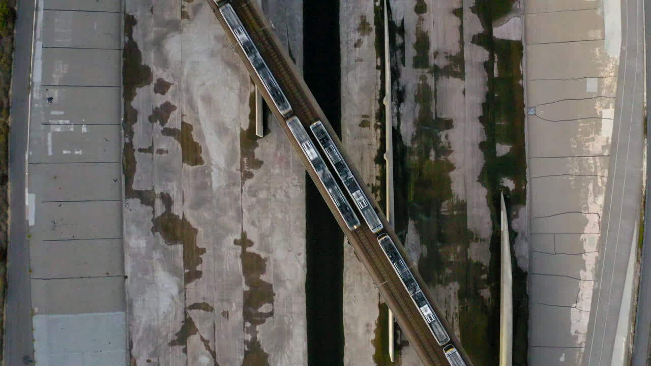 Aerial top-down view of a train crossing a bridge