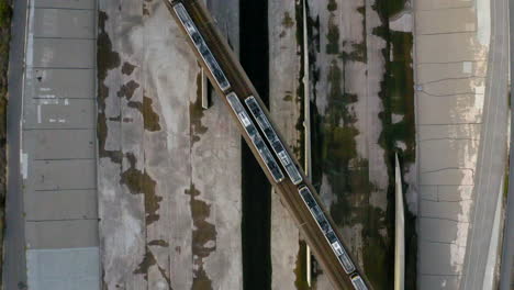 aerial top-down view of a train crossing a bridge