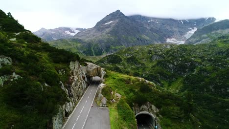 winding grimsel pass road weaving through lush green valleys and steep cliffs