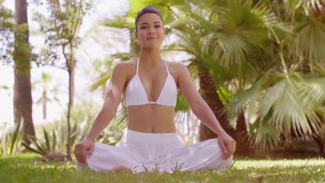 Young-woman-meditating-in-a-tropical-garden