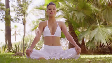 joven meditando en un jardín tropical