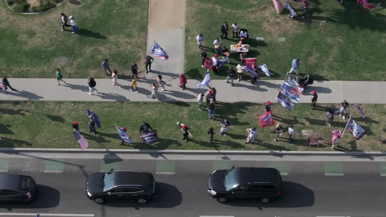 Birds-eye aerial view over crowd with support for Donald Trump for President as cars line up