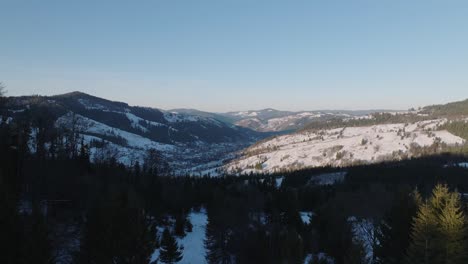 a snowy mountain valley with a large cross overlooking the landscape at sunrise