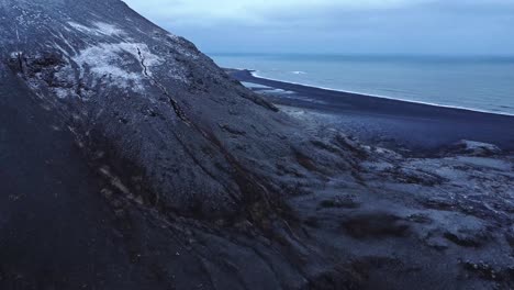 Mountain-slope-near-waving-sea