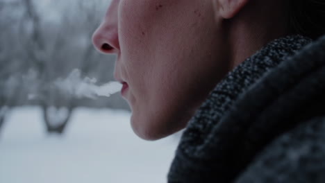 person exhaling in the snow